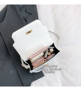 Spacious interior of white leather handbag showing phone, wallet and cosmetics layout