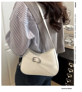 Detalle de bolso hobo blanco en cuero brillante con hebilla plateada en una modelo