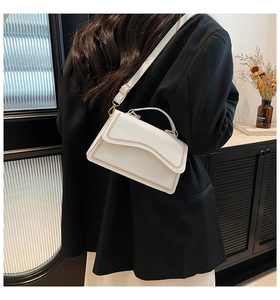 Detail of white PU leather crossbody bag with vintage woven edge and gold metal hardware