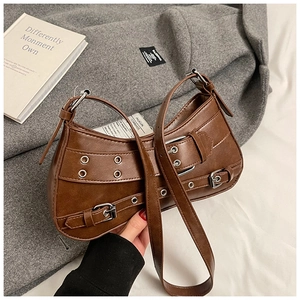 Detailed view of brown vintage punk bag with decorative leather straps and metal buckles