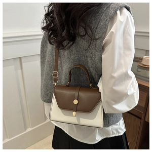 Brown and white color-block handbag styled as a crossbody bag for a casual lifestyle look