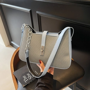 Chic underarm bag in light blue and grey woven texture with a metal twist lock clasp