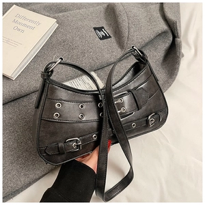 Detail of distressed grey leather bag with silver metal eyelets and punk style hardware