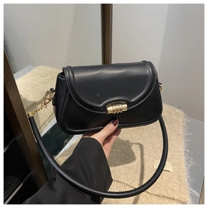 Detailed view of black minimalist shoulder bag with vintage gold spiral twist lock