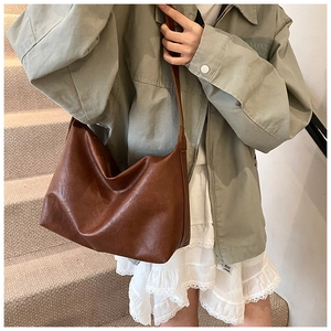 Gros plan d'un grand sac cabas marron caramel montrant la texture du cuir souple et le design