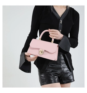 Détail du sac à main en cuir rose avec fermoir en métal doré et poignée incurvée