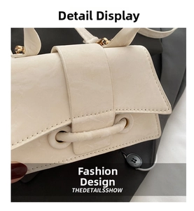 Detail shot of cream leather handbag showing fine stitching and metal eyelet accents