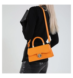 Vue détaillée du sac carré rétro orange vif avec fermoir en anneau et texture en cuir