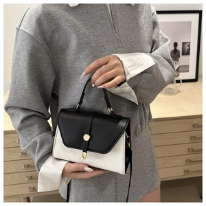 Sac à main chic en cuir bicolore noir et blanc avec fermoir en métal doré poli