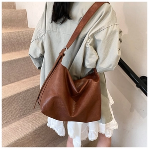 Détail d'un grand sac hobo marron avec bandoulière large et boucle métallique