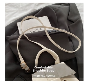 Detail of adjustable shoulder strap and gold hardware on cream crossbody bag