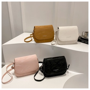 Multiple colors of pleated leather saddle bags with stamped fashion trend lettering