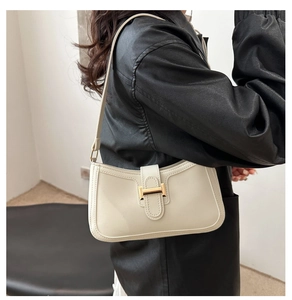 Détail du sac bandoulière en similicuir crème avec boucle en métal doré en forme de H