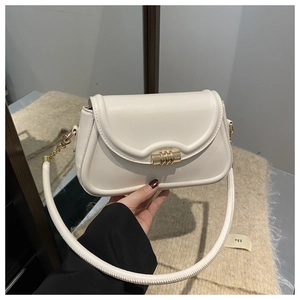 Detail of minimalist cream leather handbag with gold cylindrical metal clasp