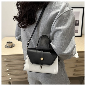 Mannequin portant un sac bandoulière noir et blanc avec boucle en métal doré