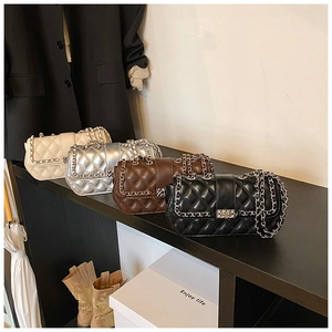 Close-up of quilted leather crossbody bags in four colors with metal chain straps