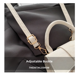 Detail of adjustable gold buckle and precision stitching on a white leather handbag