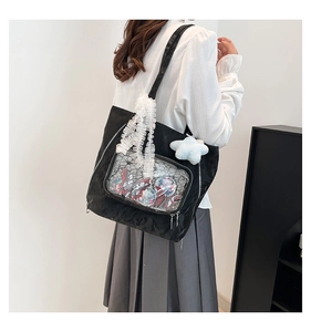 Detail of black ita bag featuring a transparent display window and white lace straps
