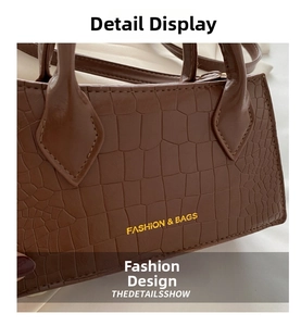 Macro detail of brown crocodile embossed leather handbag with Fashion & Bags text logo