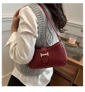 Détail du sac croissant bordeaux avec boucle H dorée et texture cuir raffinée