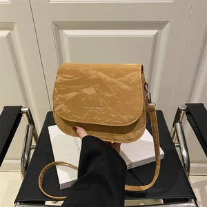 Brown saddle crossbody bag with fashion trend lettering and unique crinkled paper texture