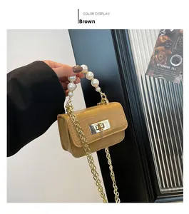 Détail du mini sac marron gaufré croco avec poignée en perles et bandoulière chaîne dorée