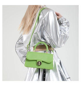 Détail du sac bandoulière vert fluo avec fermoir tournant en métal doré et poignée