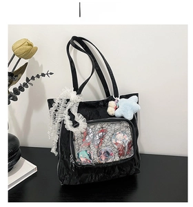 Detail of black ita bag with transparent window displaying anime pins and lace trim