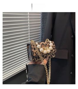 Détail du mini sac léopard avec de grandes perles blanches et une bandoulière dorée