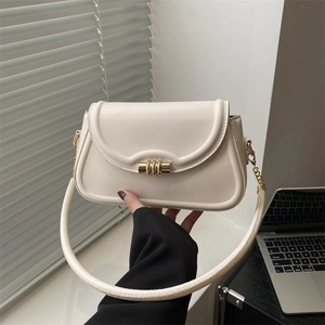 Minimalist white faux leather crossbody bag with iconic gold hardware and round handle