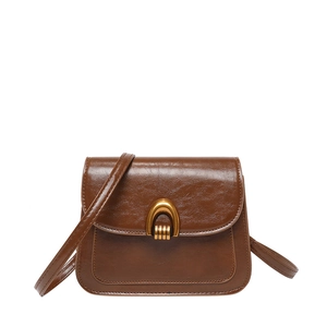 Vintage dark brown saddle bag with shiny leather texture and golden U-shaped metal lock