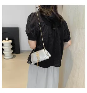 Détail du sac bandoulière en cuir plissé argenté avec logo SS doré et franges