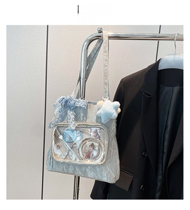 Detail of silver ita bag with transparent window, lace bow and plush star pendant