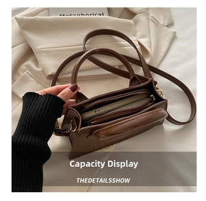 Internal view of brown crocodile texture handbag showing multi-layer compartments and capacity