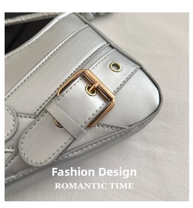 Detailed macro of silver textured leather shoulder bag with golden buckle and stitching