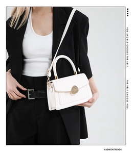 Détail du sac à bandoulière blanc motif crocodile avec fermoir métallique doré