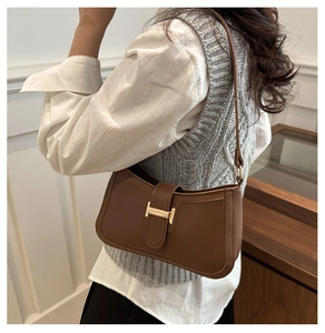 Vue détaillée d'un sac porté épaule en cuir marron avec boucle métallique dorée