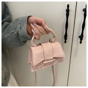 Detail of light pink mini handbag with textured marble finish and elegant short handle