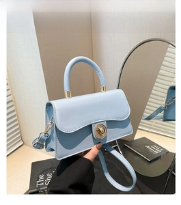 Détail d'un sac à main bleu clair en cuir huilé avec fermoir doré rotatif élégant