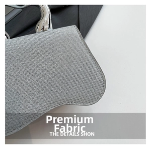 Detail of silver glitter fabric texture and sleek metallic handle on this stylish handbag