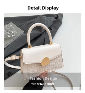 Détail du sac à main blanc en simili cuir gaufré crocodile avec fermoir métallique doré