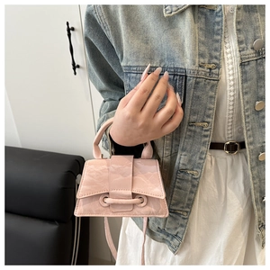 Detail of pink textured leather mini handbag showing top handle and slim crossbody strap