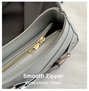 Detail of premium gold metal zipper closure on chic silver leather shoulder bag