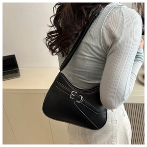 Detail of minimalist black hobo bag with silver buckle strap shown on a model