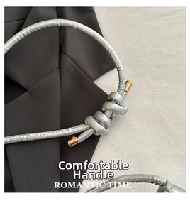 Close-up of the silver soft leather knotted handle with gold metallic cylinder ends