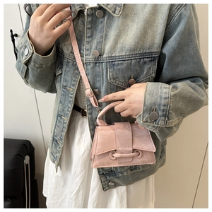 Detail of pink glossy patent leather small crossbody bag with adjustable shoulder strap