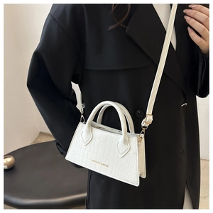 Detailed shot of white croc-embossed leather handbag featuring Fashion & Bags logo print