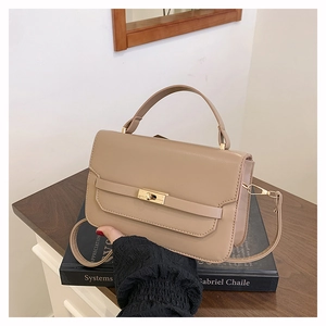 Detail of beige flap handbag with gold twist lock and fine PU leather texture