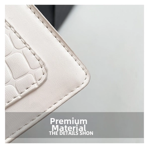 Détail du cuir blanc avec relief crocodile et surpiqûres précises sur le sac