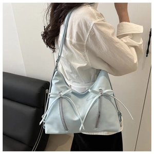 Detailansicht der hellblauen PU-Schultertasche mit dekorativen Schleifen-Reißverschlüssen